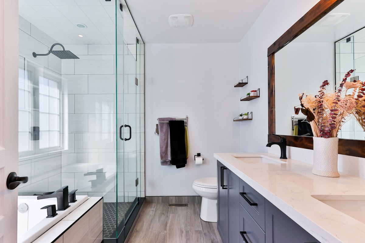 Modern bathroom with walk-in shower, stone vanity and black fittings